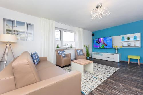 a living room with a couch and a tv at Haus zur Möwe mit Frühstücksoption in Bensersiel