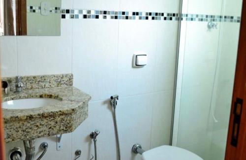 a bathroom with a shower and a sink and a toilet at Hotel Mirante do Porto in Aparecida