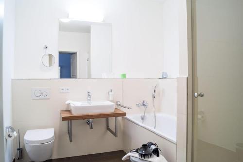 a bathroom with a sink and a toilet and a tub at Südkap D-07 in Pelzerhaken