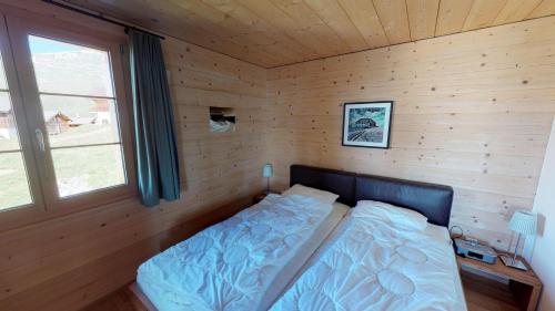 a small bedroom with a bed in a wooden room at Swantee in Belalp