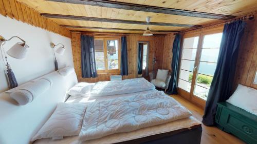 a bedroom with a large bed and a large window at Swantee in Belalp