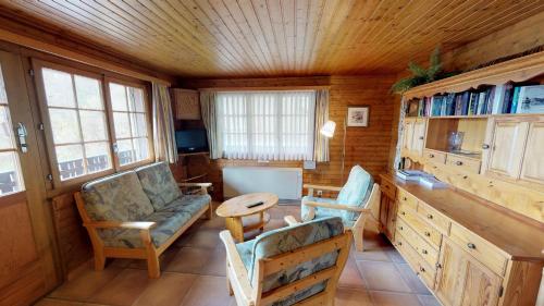een woonkamer met een bank, stoelen en een tafel bij Susy in Blatten bei Naters