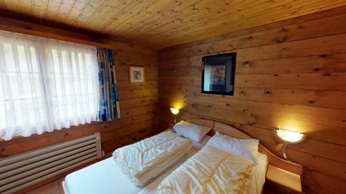 een slaapkamer met een bed in een houten muur bij Susy in Blatten bei Naters