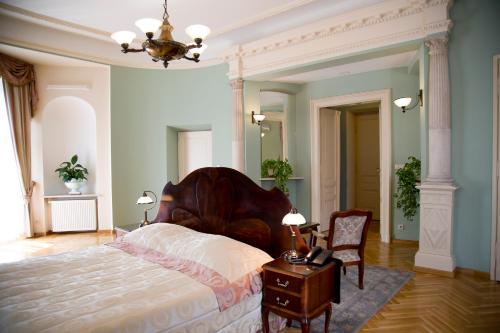 a bedroom with a bed and a table and a chair at Hotel Polonia in Kraków