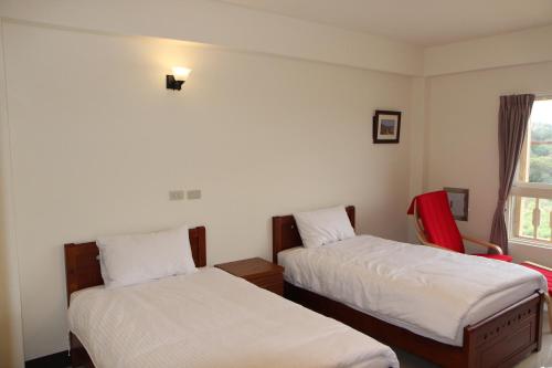 a room with two beds and a window at Dapu Inn in Juguang