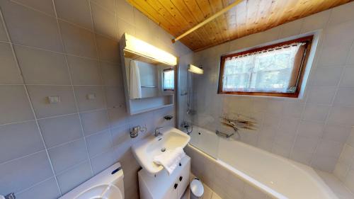 a bathroom with a sink and a toilet and a tub at Saxo in Blatten bei Naters