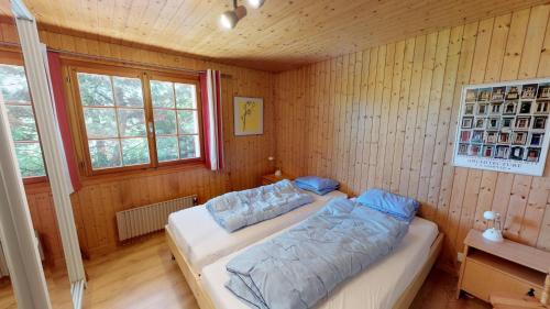 a bedroom with a bed in a room with wooden walls at Saxo in Blatten bei Naters