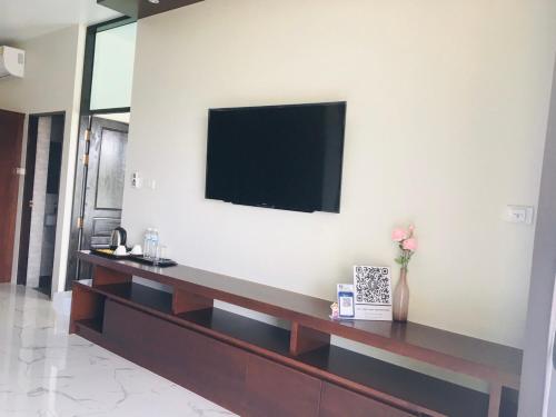 a living room with a television on a wall at Suan Son Villa Koh Sa Nher สวนสนธิ์วิลล่า เกาะเสนอ SHA in Surat Thani