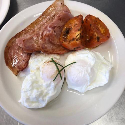 a plate of breakfast food with eggs sausage and potatoes at Ten Dollar Town Motel in Gulgong