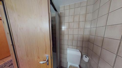 ein Bad mit einem WC und einer gefliesten Wand in der Unterkunft Mischi in Blatten bei Naters