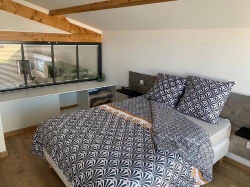 a bedroom with a bed and a window at ATELIER 85 in Les Épesses