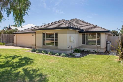 a house with a grass yard in front of it at Macs Manor in Dunsborough