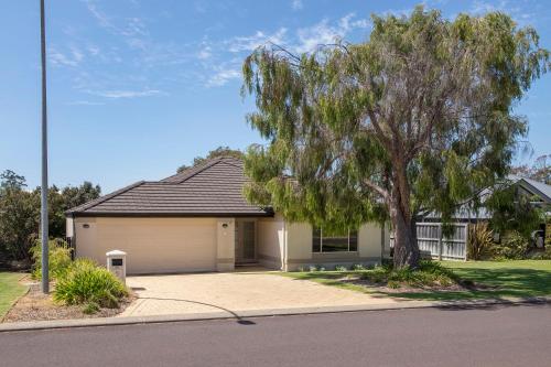 a house with a tree in front of it at Macs Manor in Dunsborough