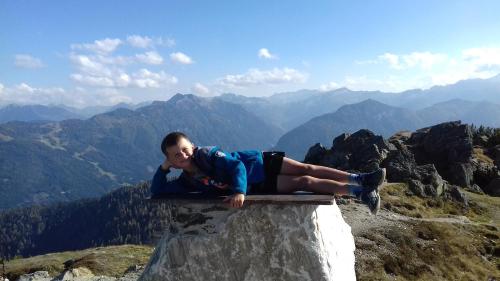 a man laying on the ledge of a mountain at Landhaus Fingerhof in Flachau