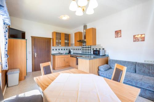 a kitchen and living room with a table and a couch at Landhaus Fingerhof in Flachau