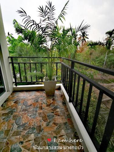 a patio with a potted plant on a balcony at Baan Glangsuan Bang Kobua in Bang Chak