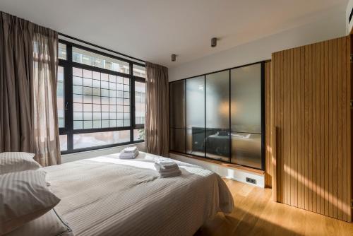 a bedroom with a large bed and large windows at Kin Athens in Athens