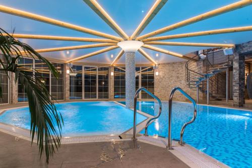 a swimming pool in a building with a large ceiling at Pałac Bielawa in Bielawa