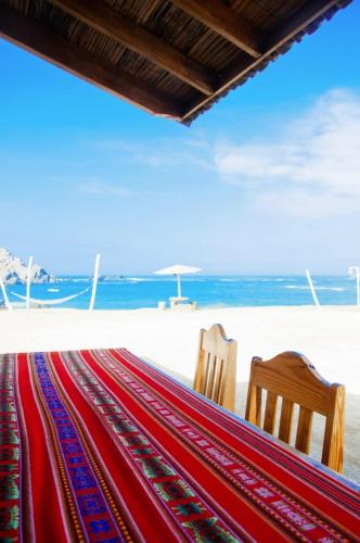 two chairs and a hammock on the beach at Hotel Puerto Inka in Chala