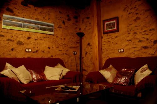 a living room with two couches and a table at La Boticaria Casa Rural Apartamento in Descargamaría