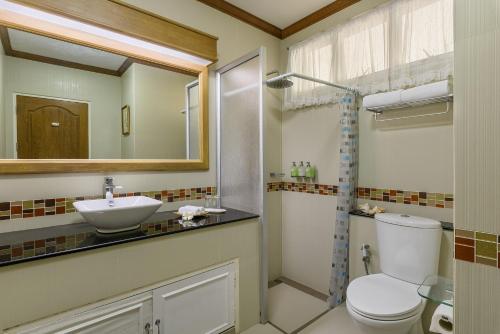 a bathroom with a toilet and a sink and a mirror at Seapine Beach Golf and Resort Hua Hin in Hua Hin