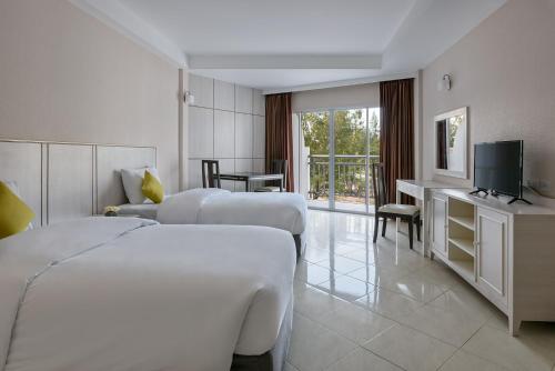a hotel room with two beds and a television at Seapine Beach Golf and Resort Hua Hin in Hua Hin
