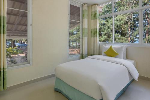 a bedroom with a white bed and two windows at Seapine Beach Golf and Resort Hua Hin in Hua Hin