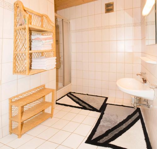 a white tiled bathroom with a sink and a toilet at Appartement Susanne in Neustift im Stubaital