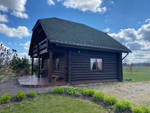 een blokhut met een terras in een veld bij Piešupīte in Staburags