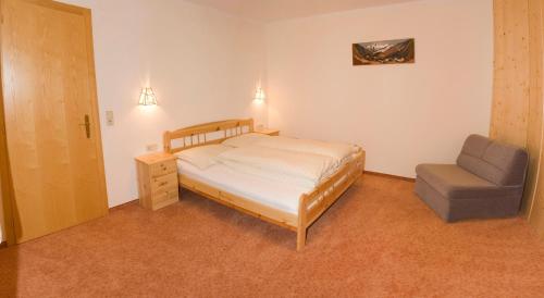 a bedroom with a bed and a chair at Appartement Susanne in Neustift im Stubaital