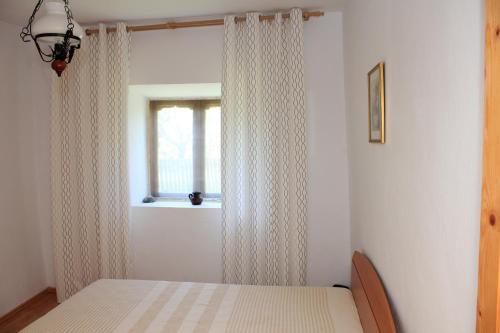 a bedroom with a bed and a window with curtains at Casa de Vacanta Sarinasuf in Sarinasuf