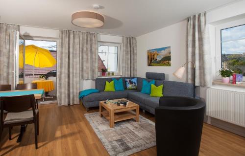 a living room with a blue couch and a table at Ferienwohnungen KUR-ECK in Bad Wörishofen