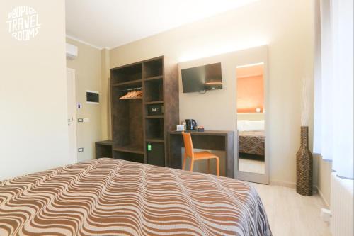 um quarto com uma cama, uma secretária e uma cama em People Travel Rooms em Bolonha