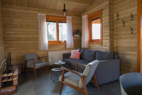 a living room with a blue couch and chairs at Vakantiehuis De Schaapskooi in Drunen
