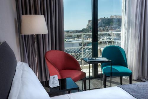 a hotel room with two chairs and a window at Astor Hotel in Athens