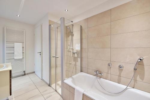 a bathroom with a tub and a shower and a sink at Scharhörn-Riff - 16 in Cuxhaven