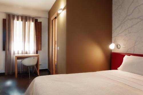 a hotel room with a bed and a desk at Giardino Sul Duomo in Ragusa