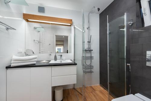 a white bathroom with a sink and a shower at ApartDomek7b Jasne Wybrzeże - nowy i luksusowy in Jastrzębia Góra