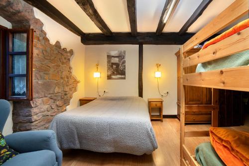 a bedroom with a bed and a stone wall at Posada Elbete in Elbete