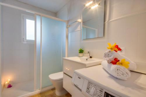 biała łazienka z toaletą i umywalką w obiekcie Ideal Property Mallorca - Sol de Mallorca 2 w Cala Mesquida