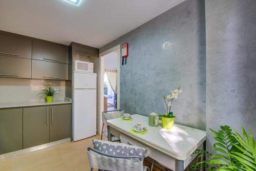 - une cuisine avec une table et des chaises blanches dans l'établissement Ideal Property Mallorca - Taronger, à Alcúdia