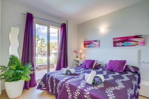 une chambre avec un lit violet et une fenêtre dans l'établissement Ideal Property Mallorca - Taronger, à Alcúdia