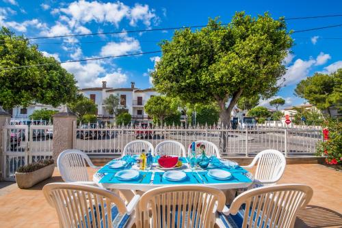 een tafel met witte stoelen en een blauwe tafeldoek bij Ideal Property Mallorca - Villa Celia in Port d'Alcudia