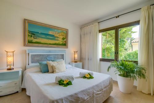 カラ・デ・サント・ビセントにあるBennassarのベッドルーム1室(大型ベッド1台、花2本付)