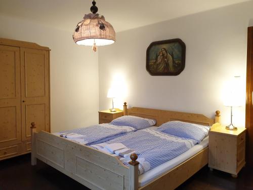 a bedroom with a bed with two lamps and a painting on the wall at Chalupa Pomněnka in Jáchymov