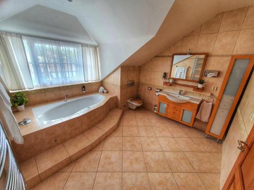 a large bathroom with a tub and a sink at Penzion Gemer in Jeseník