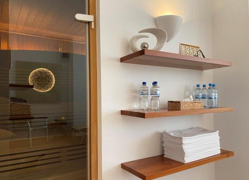 Habitación con estanterías de madera y botellas de agua. en Hotel Wünschmann, en Westerland