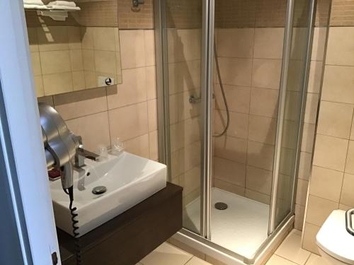y baño con ducha y lavamanos. en Hotel Restaurant Elissaldia, en Bidart