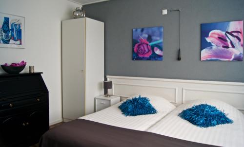 a bedroom with a bed with blue pillows on it at The Studio Guesthouse in Volendam