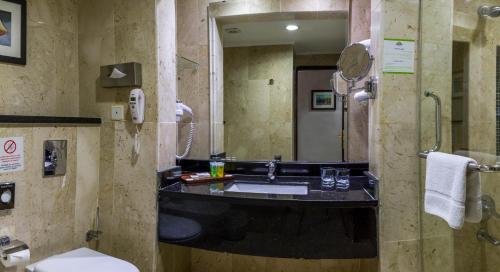 a bathroom with a sink and a toilet at Days Inn Hotel & Suites Amman in Amman